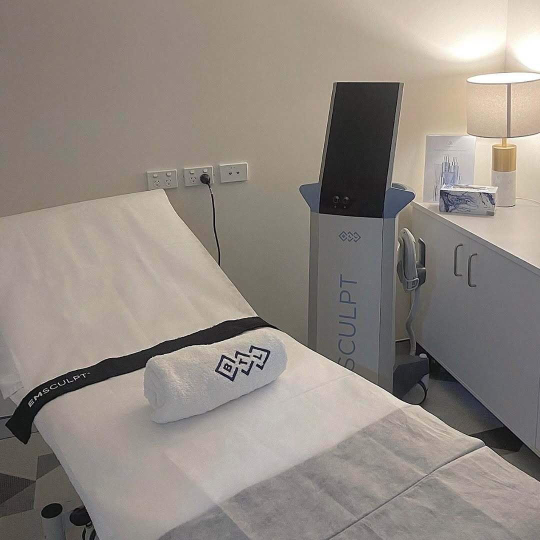 Smiling Nurse performing emsculpt on abdomen area